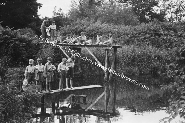 GROUP OF BOY ON DIVING BOARD BY RIVER